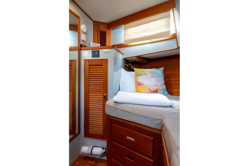 Sandy Isles Yacht Photos Pics Cozy cabin interior of 1993 Grand Banks 46 Motoryacht with wooden accents and colorful pillows.