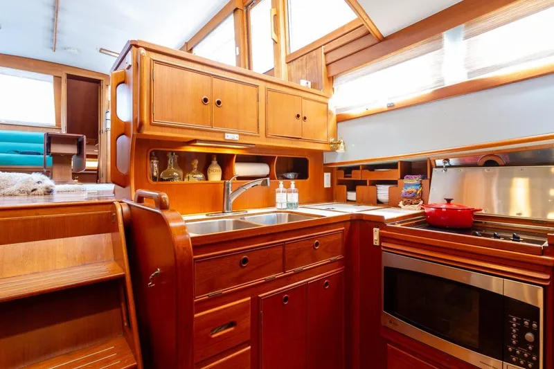 Sandy Isles Yacht Photos Pics 1993 Grand Banks 46 Motoryacht kitchen with wooden cabinetry and modern appliances.