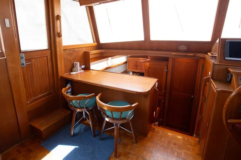 Sandy Isles Yacht Photos Pics Interior of 1993 Grand Banks 46 Motoryacht with wooden cabinetry and bar seating.