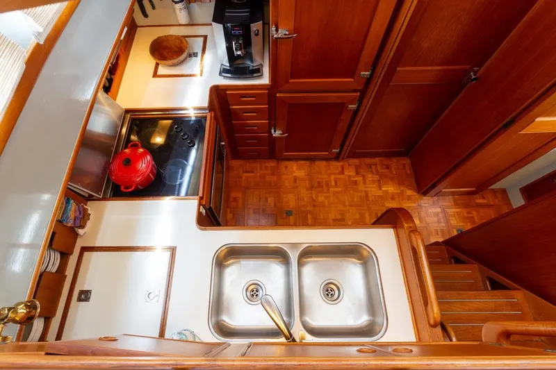 Sandy Isles Yacht Photos Pics 1993 Grand Banks 46 Motoryacht kitchen with wooden cabinetry and dual sink.