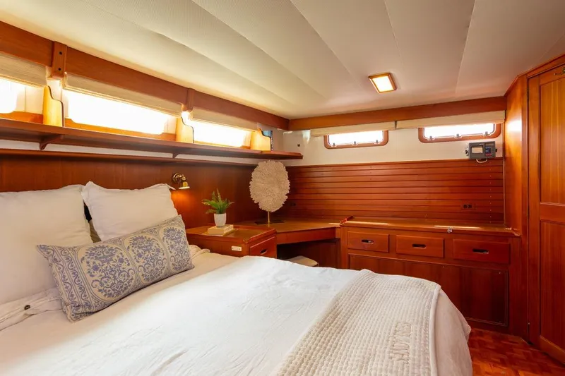 Sandy Isles Yacht Photos Pics Luxurious cabin interior of 1993 Grand Banks 46 Motoryacht with wooden furnishings and cozy bedding.
