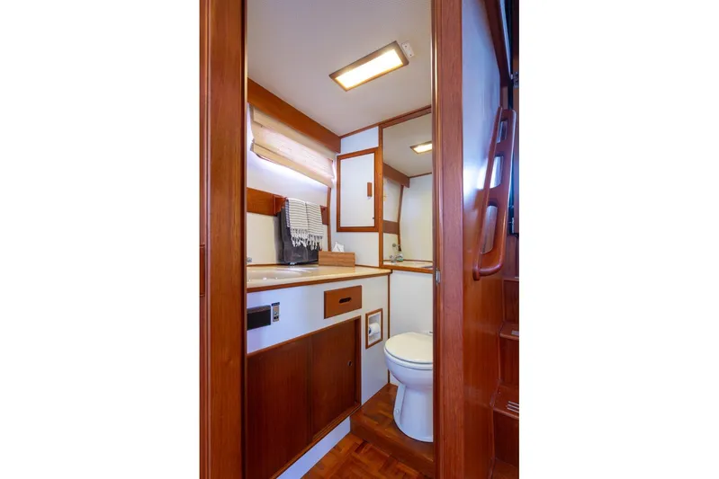 Sandy Isles Yacht Photos Pics 1993 Grand Banks 46 Motoryacht bathroom with wooden cabinetry and modern fixtures.
