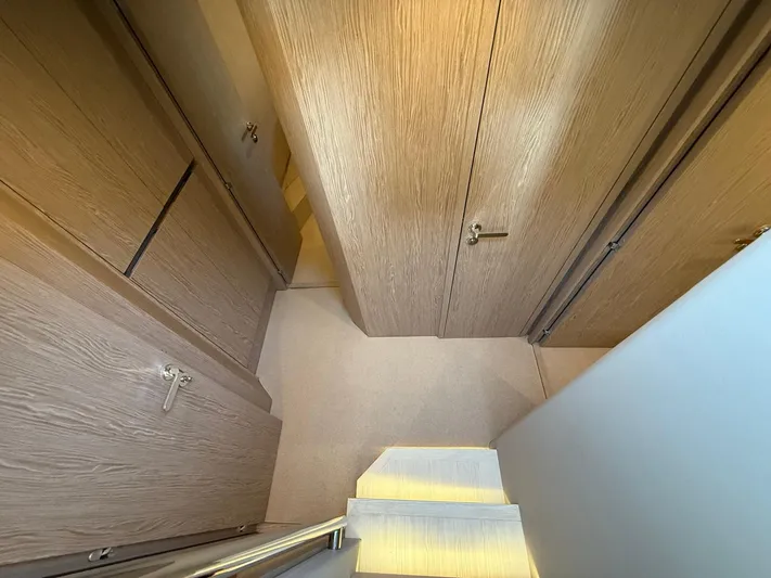  Yacht Photos Pics Interior view of 2025 Azimut Fly 53 yacht, featuring wooden cabinetry and stairs.