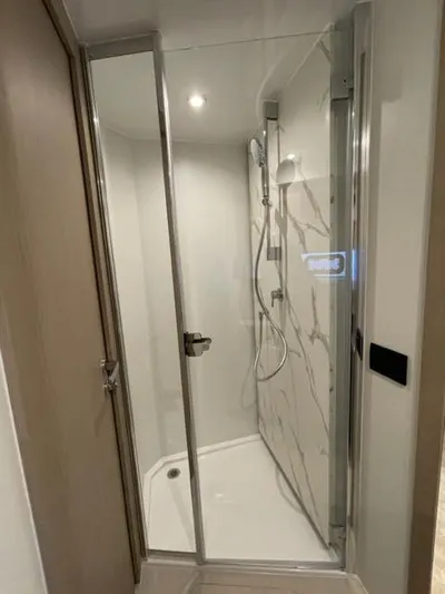  Yacht Photos Pics Modern shower cabin in 2023 Azimut Fly 53 yacht, featuring sleek glass doors and marble walls.