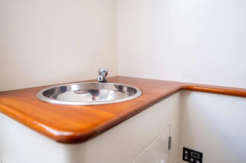 Reese Lee Yacht Photos Pics 2003 Gamefisherman 34 Express boat interior with wooden countertop and stainless steel sink.