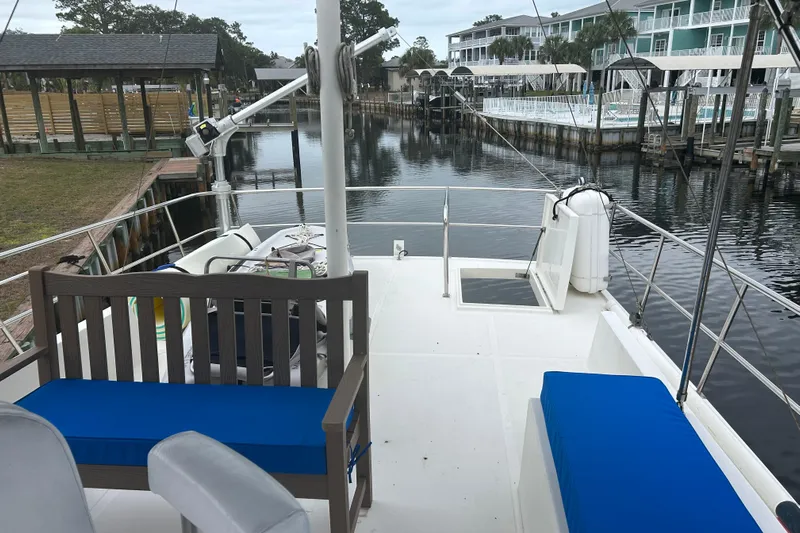  Yacht Photos Pics 2006 Mariner Orient boat docked, featuring blue cushioned seating and a serene waterfront view.