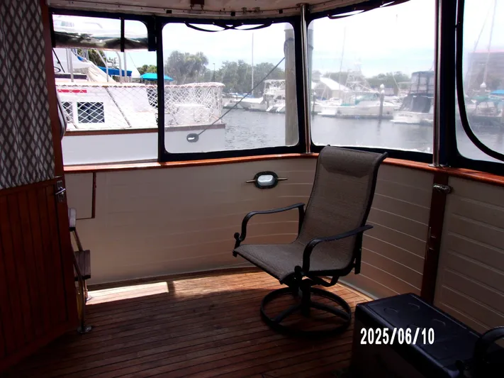 Chesapeake Yacht Photos Pics Enclosed deck of 1986 Kadey-Krogen Manatee 36 with chair, overlooking marina.