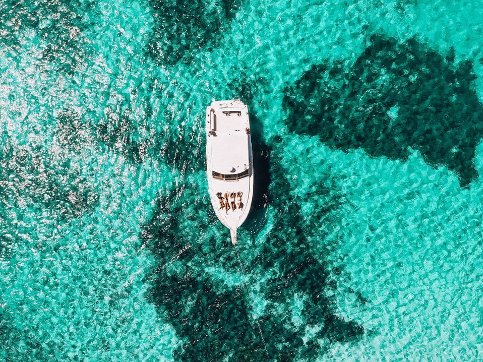 People enjoying a rental boat surrounded by turquoise waters